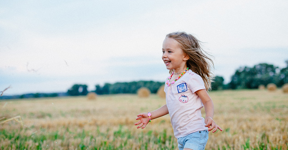 dziewczyna biegnąca przez pole